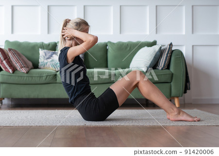 Fit woman exercising at home lying on floor doing abs workout Fitness woman doing sit ups. Fit woman exercising at home lying on floor doing abs workout Fitness woman doing sit ups. 91420006