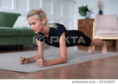 Woman doing plank exercise working out at home Woman doing plank exercise working out at home 91420007