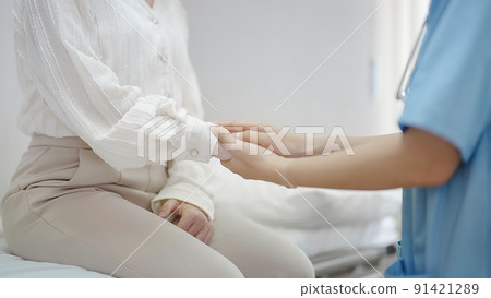 Hand of female doctor comforting patient at consulting room 91421289