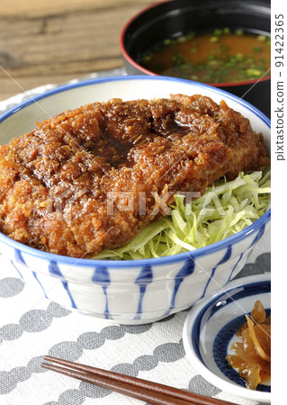 捲心菜絲、豬丼丼、味噌湯和泡菜上的大量醬汁與炸肉排的醬汁 捲心菜絲、豬丼丼、味噌湯和泡菜上的大量醬汁與炸肉排的醬汁 91422365