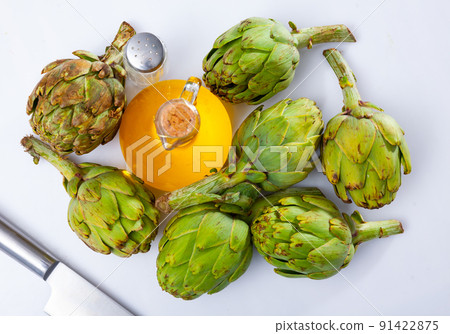 Green artichokes, oil and salt on table Green artichokes, oil and salt on table 91422875