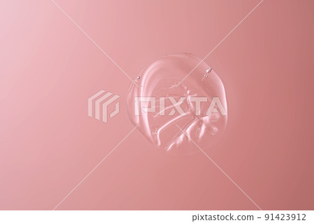 Drop of cosmetic transparent gel on a pink background. The texture of the serum, heir gel or hyaluronic booster. Drop of cosmetic transparent gel on a pink background. The texture of the serum, heir gel or hyaluronic booster. 91423912