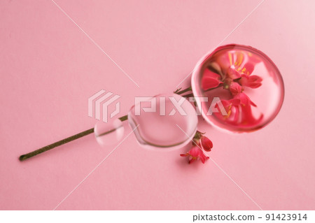 Three drops of cosmetic transparent gel on a pink background. The texture of the serum. Three drops of cosmetic transparent gel on a pink background. The texture of the serum. 91423914