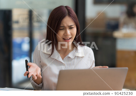 Portrait of Asian business woman worry about marketing plan of this years while talking with customer. Portrait of Asian business woman worry about marketing plan of this years while talking with customer. 91425230