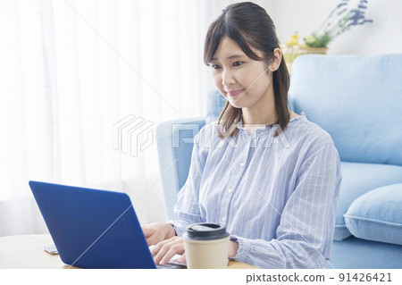 在客廳裡使用筆記本電腦的女士 91426421