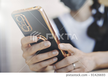 Hand of a woman holding a smartphone 91426693