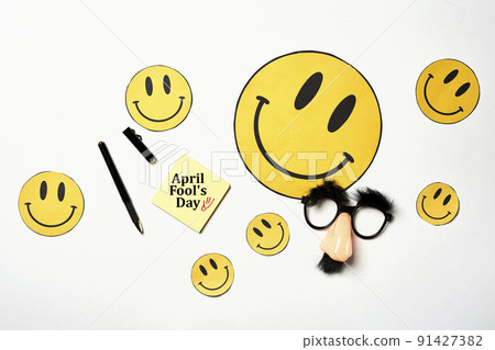 Overhead glasses with mustache and yellow smiles, April 1, joke, fools day, top view, close-up on white backgraund. Text April fools day Overhead glasses with mustache and yellow smiles, April 1, joke, fools day, top view, close-up on white backgraund. Text April fools day 91427382