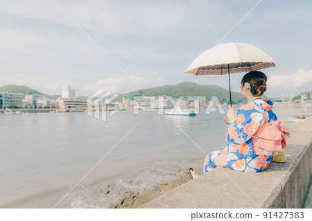 A woman in a yukata and a tourist spot in the summer sky A woman in a yukata and a tourist spot in the summer sky 91427383