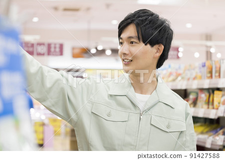 A young man in work clothes shopping at a supermarket A young man in work clothes shopping at a supermarket 91427588