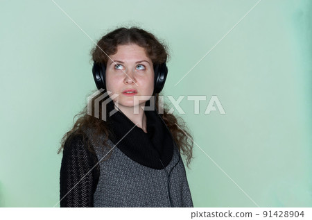 Close up portrait of pensive woman in headphones Close up portrait of pensive woman in headphones 91428904