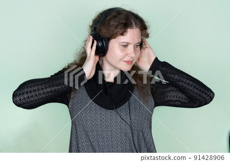 Smiling woman listening to music with headphones. Close up portrait Smiling woman listening to music with headphones. Close up portrait 91428906