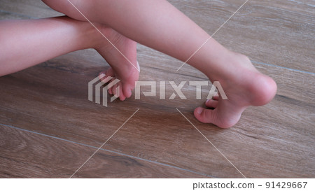 Children feet slide on wooden laminate at home Children feet slide on wooden laminate at home 91429667