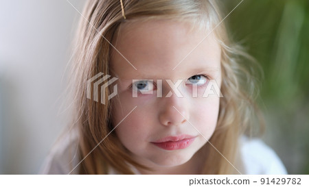 Portrait of pensive serious little child girl looks up 91429782