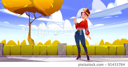 Woman in autumn city park waving hand on street 91433764