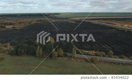 Green and brown rural fields with blue sky in autumn time in Ural 91434822