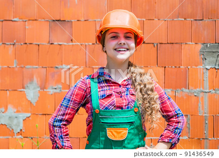 kid wear helmet on construction site. teen girl builder kid wear helmet on construction site. teen girl builder 91436549
