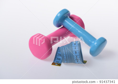 Barbells next to cyan measure tape, close up. Fitness symbols 91437341
