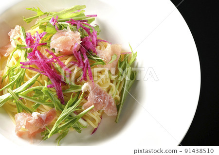A bird's-eye view of cold pasta using red radish, mizuna, prosciutto, and capellini on a black background A bird's-eye view of cold pasta using red radish, mizuna, prosciutto, and capellini on a black background 91438510