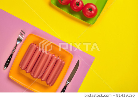 Sausages on a yellow and pink minimal background. Flat lay. Top view. 91439150