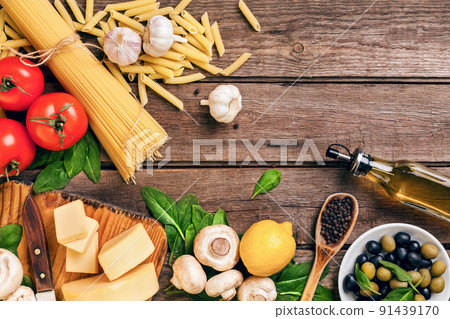 Ingredients for spaghetti with basil, tomatoes, cheese on wooden background, top view, place for text 91439170