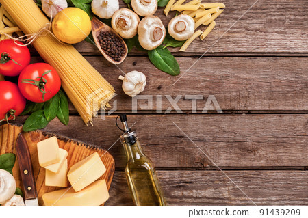 Ingredients for spaghetti with basil, tomatoes, cheese on wooden background, top view, place for text 91439209