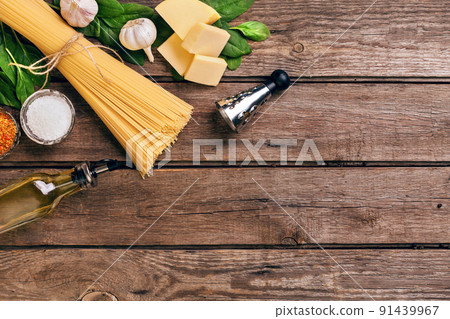 Pasta and ingredients on wooden background with copy space. Top view. Vegetarian food, healthy or cooking concept. Pasta and ingredients on wooden background with copy space. Top view. Vegetarian food, healthy or cooking concept. 91439967