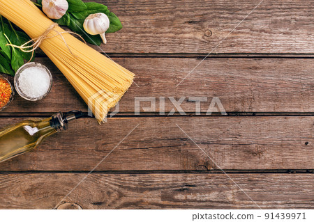 Pasta and ingredients on wooden background with copy space. Top view. Vegetarian food, healthy or cooking concept. 91439971