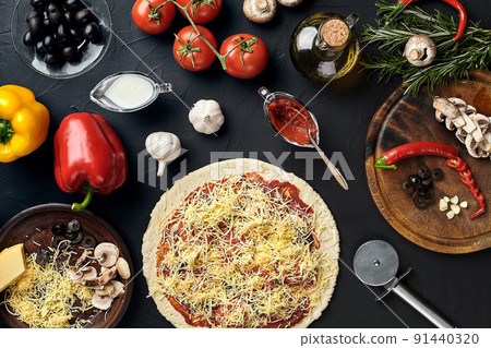 Raw pizza ingredients on black texture table background Raw pizza ingredients on black texture table background 91440320