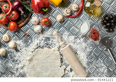 Ingredients and dough for making pizzas with an overhead view on freshly mixed mounds of pastry, a jar of olive oil and pot of tomato sauce, overhead view Ingredients and dough for making pizzas with an overhead view on freshly mixed mounds of pastry, a jar of olive oil and pot of tomato sauce, overhead view 91441221