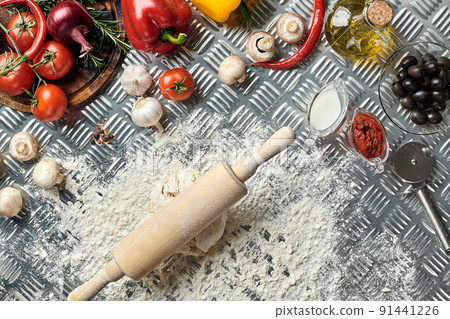 Ingredients and dough for making pizzas with an overhead view on freshly mixed mounds of pastry, a jar of olive oil and pot of tomato sauce, overhead view Ingredients and dough for making pizzas with an overhead view on freshly mixed mounds of pastry, a jar of olive oil and pot of tomato sauce, overhead view 91441226