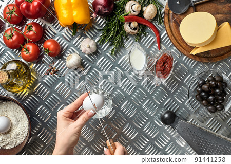 Set of ingredients for pizza and baker's hand smash eggs on metal table Set of ingredients for pizza and baker's hand smash eggs on metal table 91441258