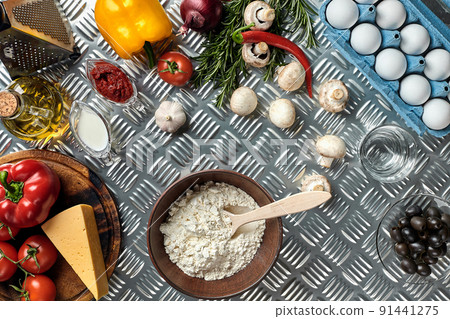 Food ingredients and spices for cooking pizza. Mushrooms, tomatoes, cheese, onion, oil, pepper, salt, egg, grater on metal background. Copy space. Top view 91441275