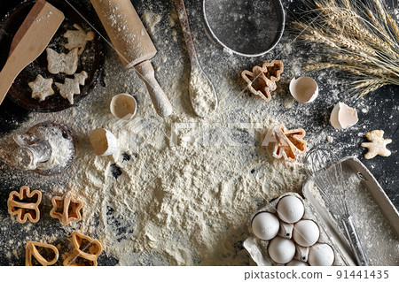 Cooking dough for cookies, butter, eggs, cooking equipment, flour on a black table. Top view with copy space, mockup for menu, recipe or culinary classes. Baking background. 91441435