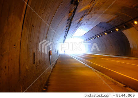The shadow of a person heading beyond the tunnel 91443009