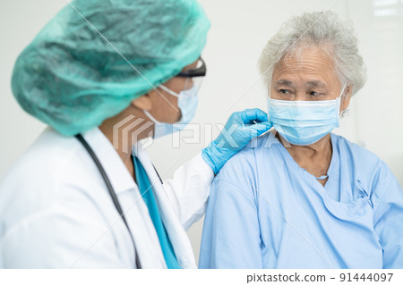 Doctor help Asian senior or elderly old lady woman patient wearing a face mask in hospital for protect safety infection and kill Covid-19 Coronavirus. Doctor help Asian senior or elderly old lady woman patient wearing a face mask in hospital for protect safety infection and kill Covid-19 Coronavirus. 91444097