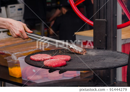 Chef grilling meat cutlets for burgers - close up 91444279