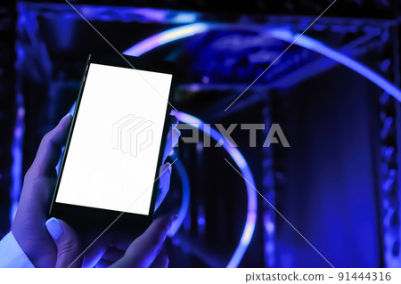 Close up: woman holding smartphone device with white display - mock up 91444316