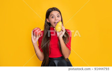 cheerful amazed kid hold fresh apple and pear on yellow background cheerful amazed kid hold fresh apple and pear on yellow background 91444793