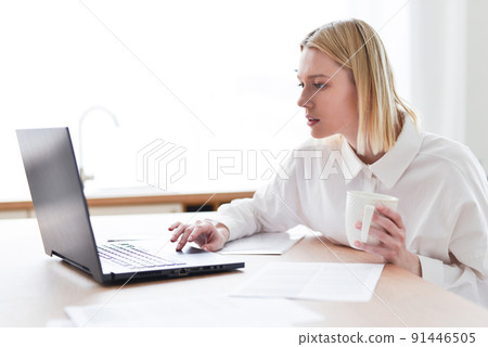 Woman at her desk with laptop 91446505