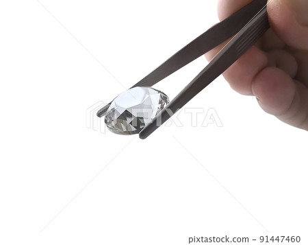 brilliant cut diamond held by tweezers isolated on white background 91447460