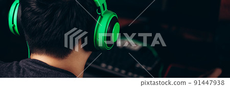 Back view of gamer in headphones playing video game Back view of gamer in headphones playing video game 91447938