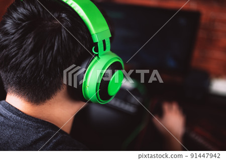 Back view of gamer in headphones playing video game Back view of gamer in headphones playing video game 91447942