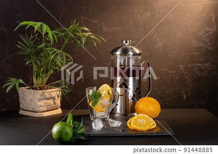 A teapot with tea and a cup with ice. Ice and mint in a glass. Preparation of cold tea. A teapot with tea and a cup with ice. Ice and mint in a glass. Preparation of cold tea. 91448885