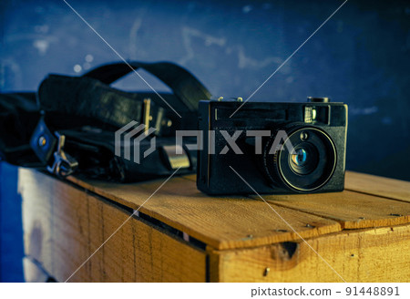 Film camera and beautiful lens flare. Vintage photo with an old camera. Camera and bag. 91448891