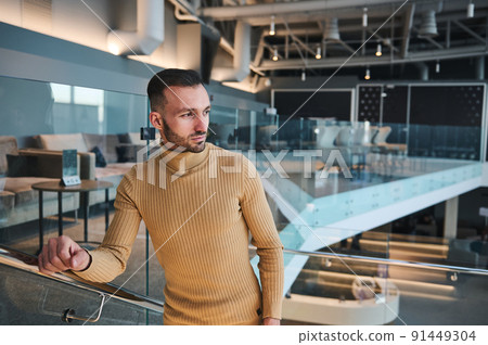 Handsome Middle Eastern man looking away while walking up stairs in VIP lounge of international airport departure terminal, waiting to board flight Handsome Middle Eastern man looking away while walking up stairs in VIP lounge of international airport departure terminal, waiting to board flight 91449304