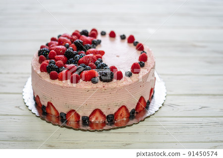 Home made cake with berries. Cake with Strawberry, blackberry, blueberry, and raspberry on a table 91450574