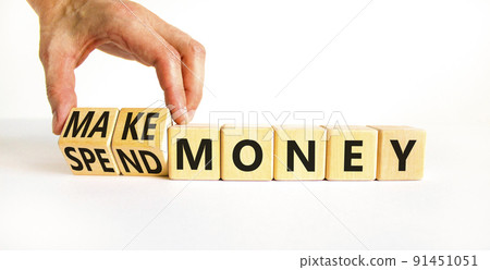 Spend or make money symbol. Businessman turns cubes and changes concept words Spend money to Make money. Beautiful white table white background. Business spend or make money concept. Copy space. 91451051