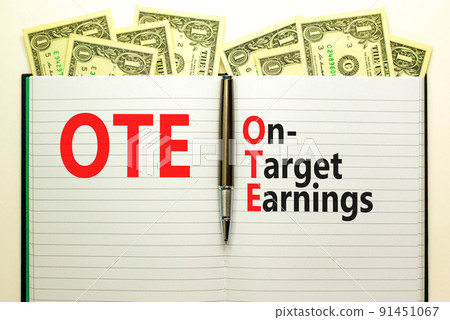 OTE on-target earnings symbol. Concept words OTE on-target earnings on white note on a beautiful white background. Dollar bills. Metallic pen. Business and OTE on-target earnings concept. Copy space. OTE on-target earnings symbol. Concept words OTE on-target earnings on white note on a beautiful white background. Dollar bills. Metallic pen. Business and OTE on-target earnings concept. Copy space. 91451067