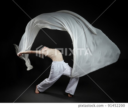 red-haired male dancer demonstrates the choreographic elements of the dance. photo shoot in the studio on a dark background 91452200