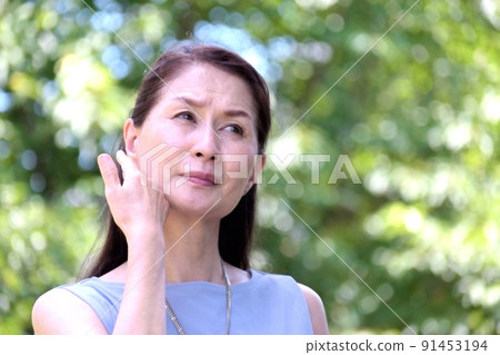 在陽光強烈的公園裡，健康狀況不佳的老年婦女 91453194